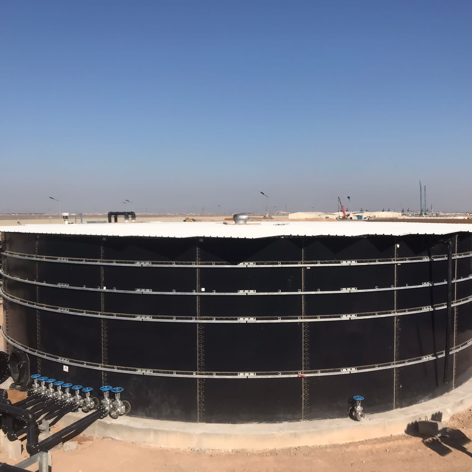 Storage tank with valve manifold and piping at an Iraqi oil and gas facility