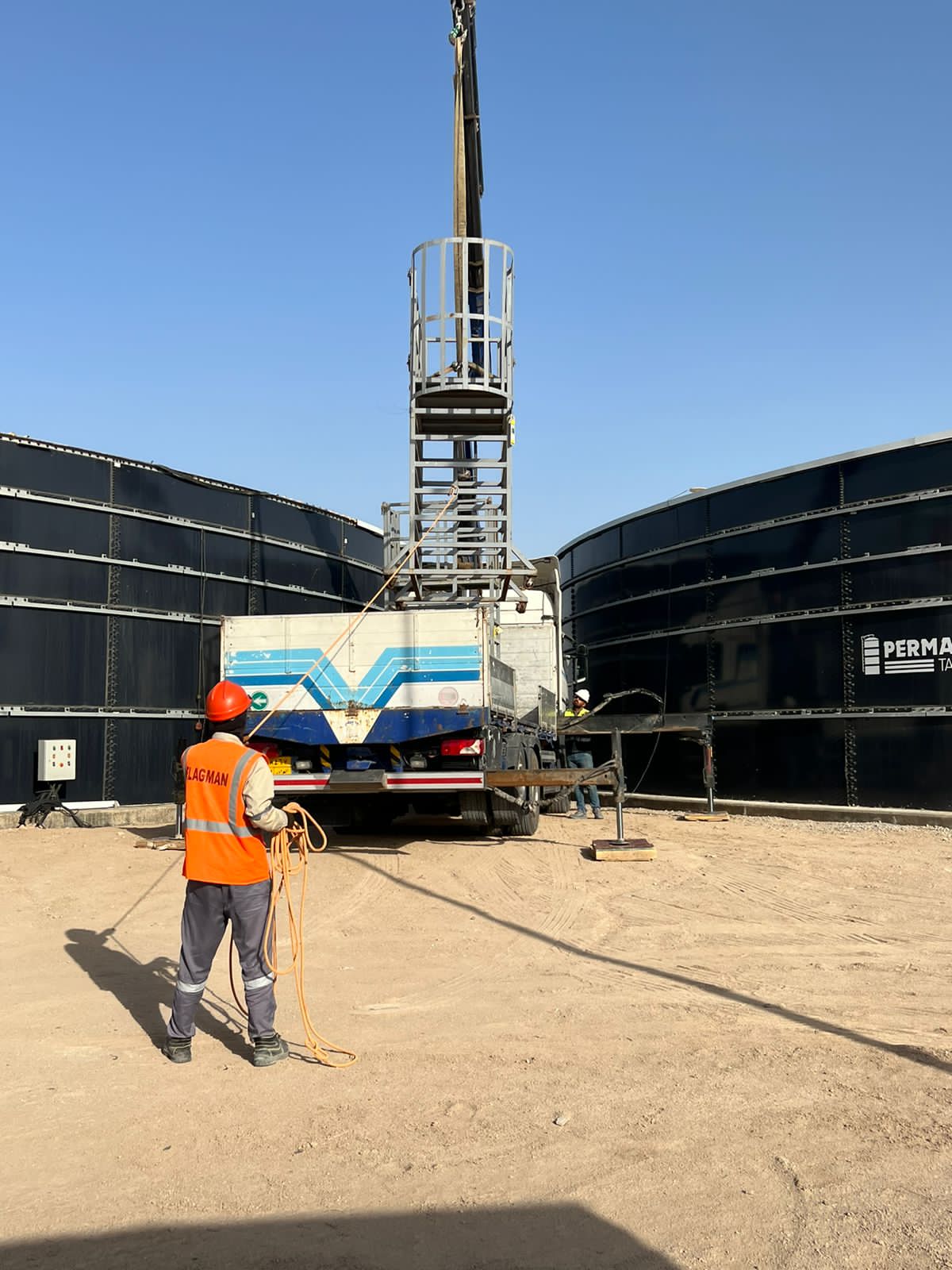 Mobile crane working alongside a completed glass-fused storage tank