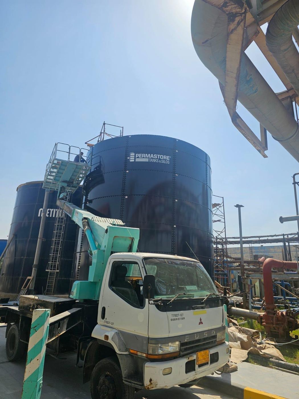 Permastore glass-fused bolted tanks with a truck-mounted access platform during site works